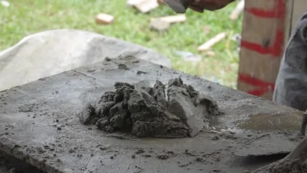一名建筑工人的手 将水泥和沙子与铲子混合在一起 — 图库视频影像