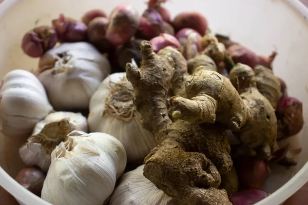 stock image Garlic, onion, candlenut and ginger are placed in the same container