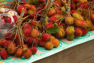 Masanın üzerine konulan çimenler, sokak yiyecekleri satıcıları tarafından satılan Rambutan.