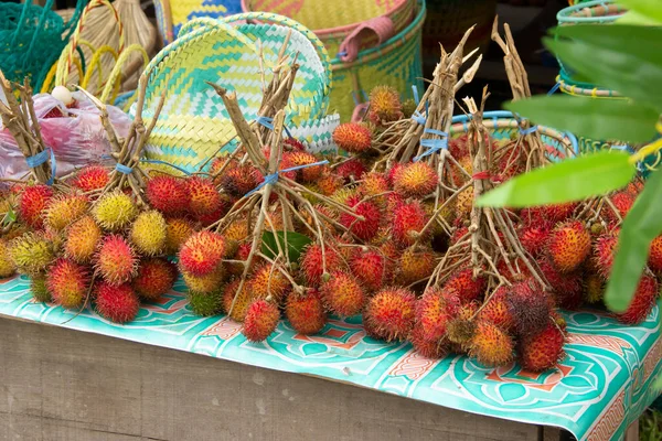 Masanın üzerine konulan çimenler, sokak yiyecekleri satıcıları tarafından satılan Rambutan.