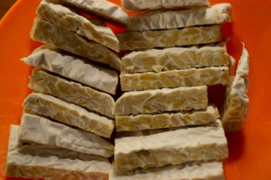 Masanın üzerine yerleştirilmiş plastik bir kapta tempeh.