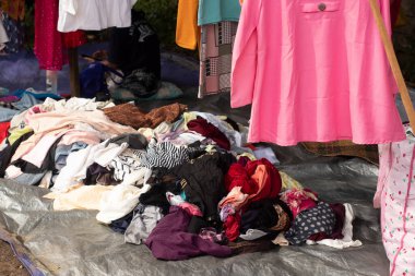 Sokak satıcıları, şapkalar, çantalar, gömlekler ve pantolonlar tarafından sergilenen çeşitli türde mallar.