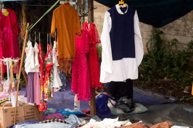 Sokak satıcıları, şapkalar, çantalar, gömlekler ve pantolonlar tarafından sergilenen çeşitli türde mallar.