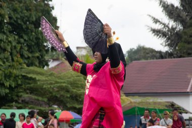 Linggang Bigung, Batı Kutai, Doğu Kalimantan, Endonezya - 1 Kasım 2022 - Pakarena Fan Dansı Bodo elbiseli Bugis geleneksel giysileri içinde, Linggang Bigung köyünün baraka töreninde.