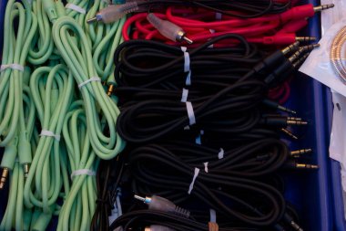 Plastik bir kabın üzerine yerleştirilmiş kırmızı, siyah ve yeşil kablo koleksiyonu.