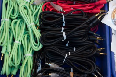 Plastik bir kabın üzerine yerleştirilmiş kırmızı, siyah ve yeşil kablo koleksiyonu.