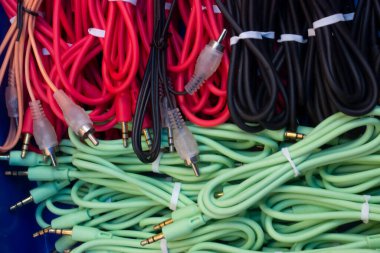 Plastik bir kabın üzerine yerleştirilmiş kırmızı, siyah ve yeşil kablo koleksiyonu.