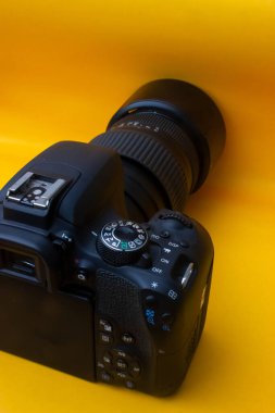 Sarı arkaplanda DSLR kamerası