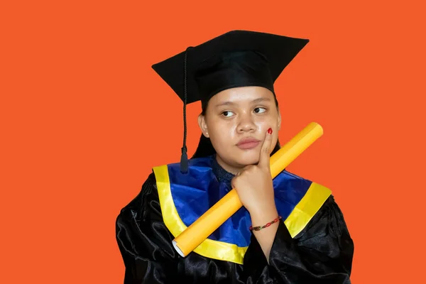 Confused young woman in graduation gown after graduation. confused concept after graduation