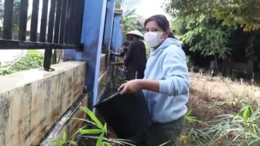 Kutai Kartanegara, Doğu Kalimantan, Endonezya - 19 Haziran 2021 - gençler ve ebeveynler çiti ve çevreyi temiz tutmak için birlikte çalışıyorlar.