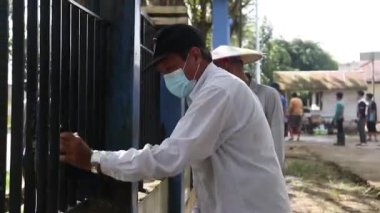 Kutai Kartanegara, Doğu Kalimantan, Endonezya - 19 Haziran 2021 - gençler ve ebeveynler çiti ve çevreyi temiz tutmak için birlikte çalışıyorlar.