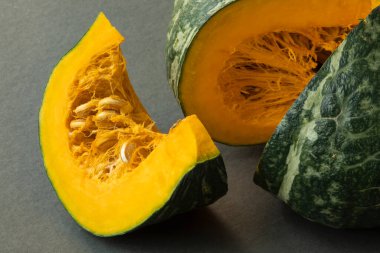 Closeup view of a slice of kabocha squash on gray background