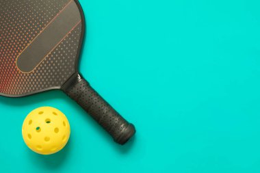 Pickleball 'un üst görüntüsü ve su mavisi arkaplanda fotokopi alanı olan top