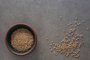 Yeşil mercimeklerin üst görüntüsü beton yüzeyde yeşil bir klozet içinde, yakınına mercimek yığını dökülmüş, fotokopi alanı da var.