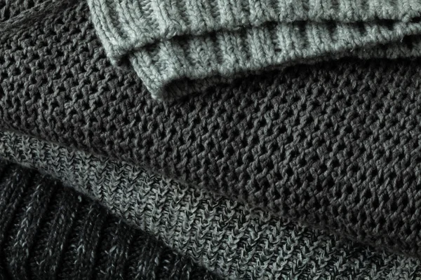 Örgü örülmüş gri kazak yığınının yakın görüntüsü. Süveter hava konsepti.