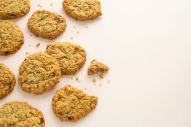 Açık pembe zemin üzerinde kuru üzümlü kuru üzümlü kurabiyelerin üst açı görünümü ve fotokopi alanı