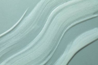 Açık mavi arka planda lekelenmiş cilt kreminin yakın görüntüsü