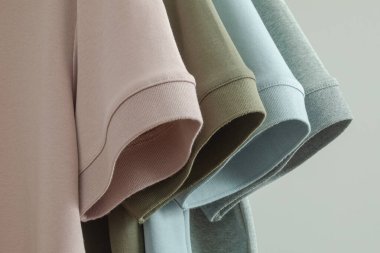 Dört erkeğin pamuklu tişörtlerinin farklı renklerde kollarını kapat