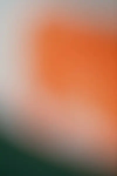 Rengi turuncu, yeşil ve gri olan bulanık, soyut bir arkaplan. Tasarım, ağ veya markalaşma için minimalist yumuşak odak dokusu ideal.