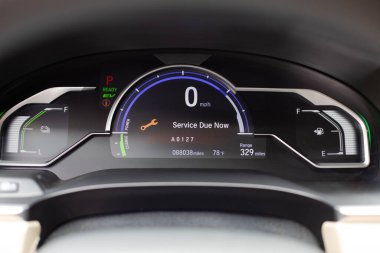 Hız göstergesini, yakıt göstergesini ve acil durum uyarısını gösteren modern bir arabanın yakın görüntüsü. İç görünüm