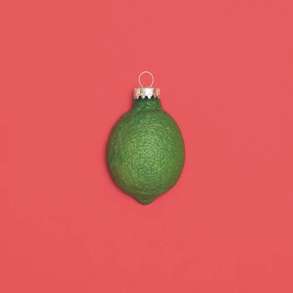 流行的想法 由切片绿色柠檬 与圣诞铝质装饰的红色背景 最小圣诞节的概念 — 图库照片
