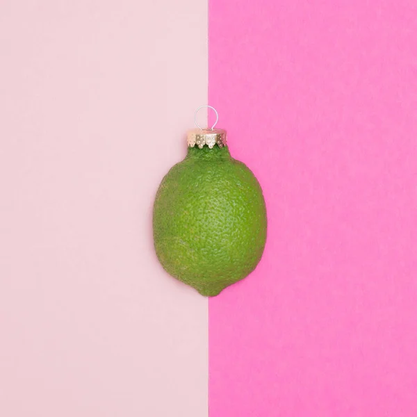 Limão Verde Linha Com Decoração Bugiganga Natal Fundo Rosa Conceito — Fotografia de Stock