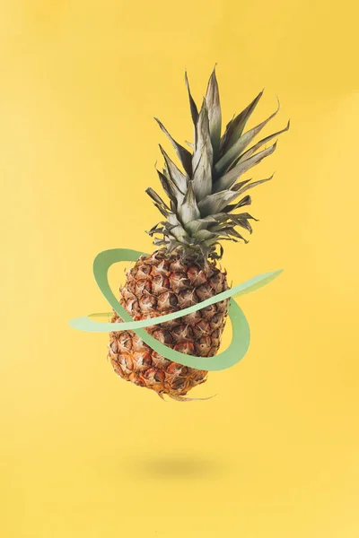 一个乳白色的黄色背景 有成熟的菠萝和绿色纸圈 最小创意水果的概念 垂直框架 — 图库照片