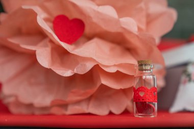 Glass jar with a heart in gift decorations.