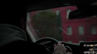 Şehirde pahalı lüks bir araba kullanan çekici bir adam.