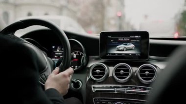 Şehirde pahalı lüks bir araba kullanan çekici bir adam.