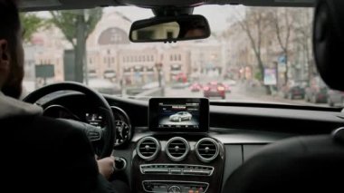 Şehirde pahalı lüks bir araba kullanan çekici bir adam.