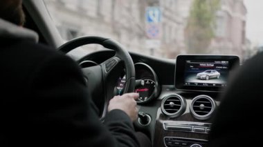 Şehirde pahalı lüks bir araba kullanan çekici bir adam.