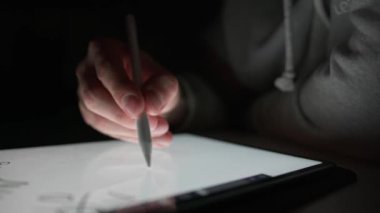 Bir adam özel bir kalem ve dijital çizim kullanarak tablete 
