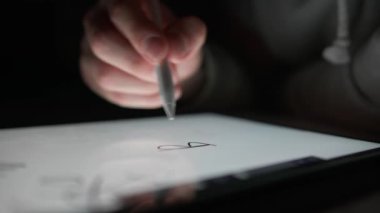 Bir adam özel bir kalem ve dijital çizim kullanarak tablete 
