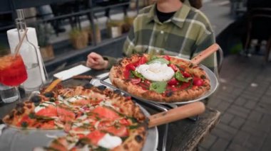 Yakın plan, caddedeki restoranın terasında pizza yeme süreci.