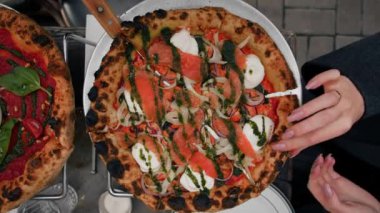Yakın plan, caddedeki restoranın terasında pizza yeme süreci.