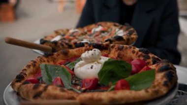 Yakın plan, caddedeki restoranın terasında pizza yeme süreci.