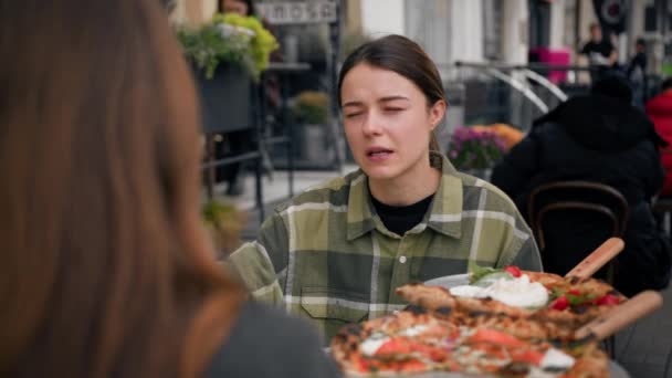 两个朋友在阳台上的一家餐馆相遇 他们吃披萨 喝鸡尾酒 — 图库视频影像
