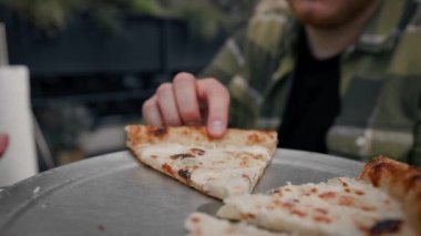 Bir kadınla randevuya çıkan adam pizza yer ve şakalar yapar.