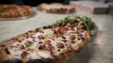 Lokanta mutfağında küçük bir biberli pizzanın yakın çekimi.