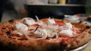 Yakın plan - balıklı lezzetli pizza - şef restorandaki pizzayı süslüyor