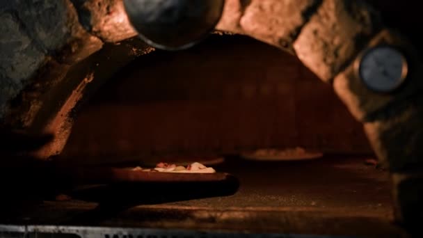 プロのシェフが伝統的なマルガリータピザを作っています ピザは石炭を入れた熱いオーブンに送られます — ストック動画