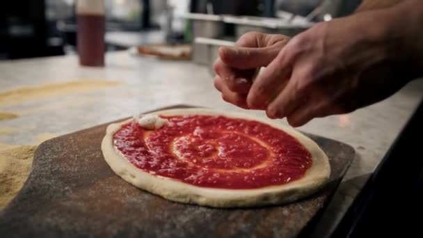 プロのシェフが伝統的なマルガリータピザにトマトペーストとチーズをピザに追加します — ストック動画