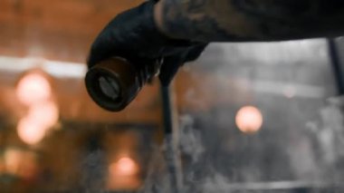 Restoranın mutfağındaki şef hamburgerler için pirzola yapar. Biftek ezer.