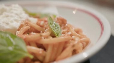 Yakın plan - restoranda dönen bir masada makarna, arka planda bulanık bir şekilde çalışan bir restoran.