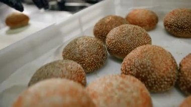 Bir restoranın profesyonel mutfağında aşçı. Hamburger ekmeği kesiyor.