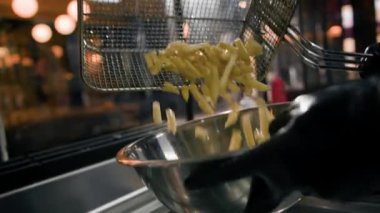 Yakın çekim. Profesyonel bir restoranın mutfağında patates kızartması pişirme işlemi.
