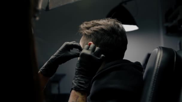 Studio Tattoo Piercing Wanita Membuat Tindik Telinga Kepada Seorang Pria — Stok Video