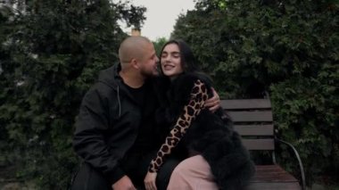Sokak - bir adam ve bir kadın parkta bir bankta oturuyor, evli bir çift öpüşüyor.