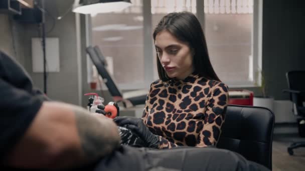 在纹身过程中 女纹身师严肃地看着相机 纹身工作室 — 图库视频影像